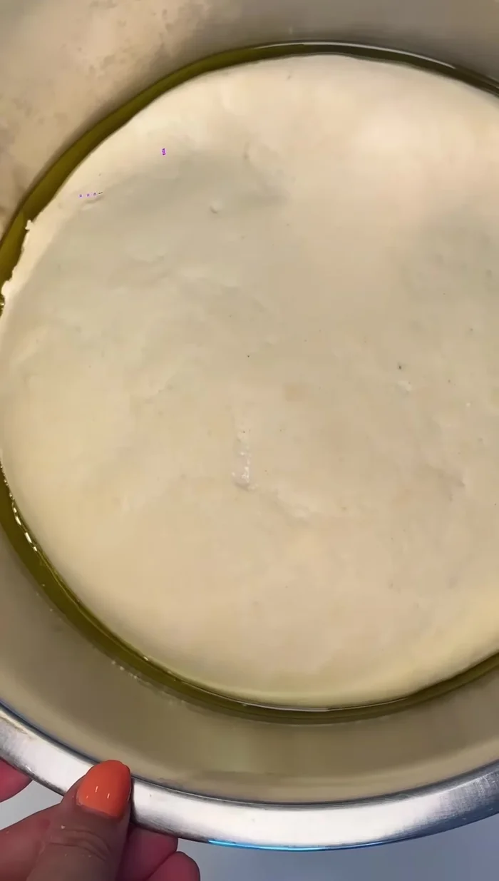 Once the focaccia dough has doubled, transfer it to a generously oiled tray. Stretch it to the corners and let rise for 30-45 minutes.