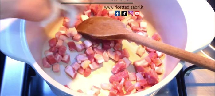 In a saucepan, without adding fat, add the bacon or guanciale and the onion.