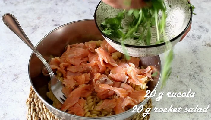 Combine cold pasta, marinated salmon, and rocket. Season with pepper.