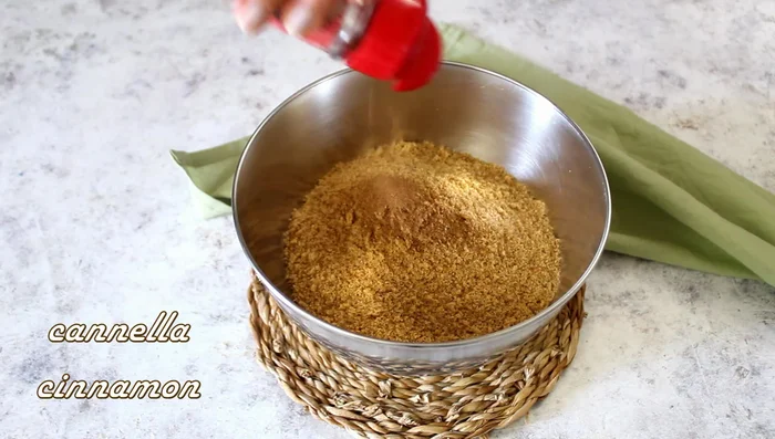 Combine the blended biscuits in a bowl with 1 teaspoon of cinnamon and 120g of melted butter. Mix until it resembles wet sand.