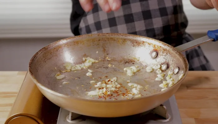 Add crushed red pepper (optional) and cook for a few seconds. Add the cooked broccoli to the pan.