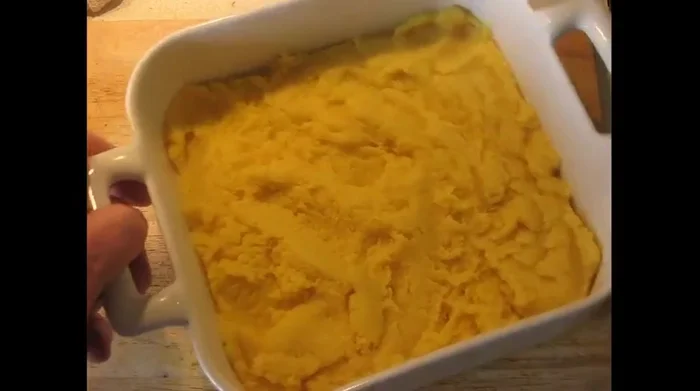 Spoon the polenta into the dish, press it down to create a uniform thickness, and smooth the top.