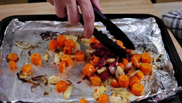 Add tomato paste to the roasted vegetables in the oven and bake for another 10 minutes.