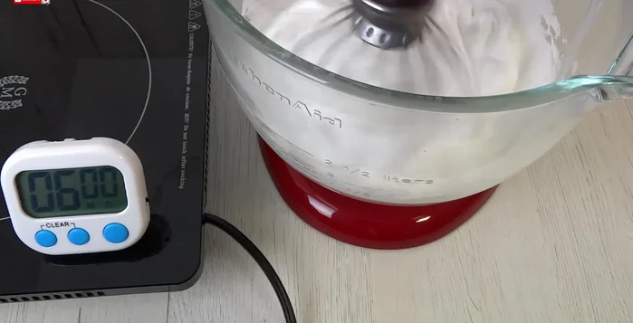 Pour the hot syrup into the egg whites slowly while mixing continuously at high speed until the bowl is warm.