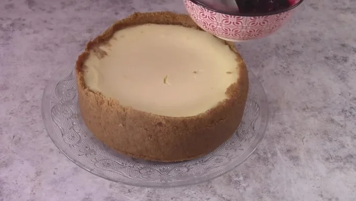 Finish the cheesecake: Top the cooled cheesecake with the berry sauce.