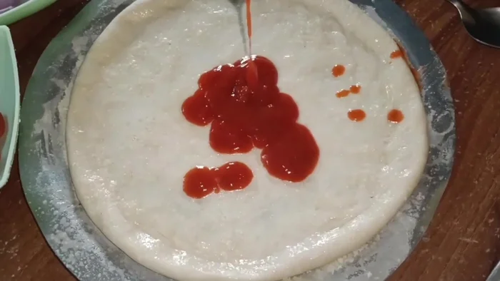 For the Italian pizza: Spread tomato and chili puree, add normal cheese and mozzarella cheese. Add basil leaves and Italian seasoning.