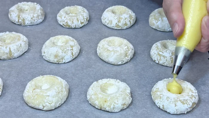 Once completely cool, fill the cookies with lemon curd using a teaspoon or piping bag.
