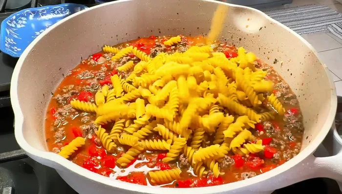Add 8 oz of rotini pasta, stir, and ensure enough liquid (add more broth if needed).