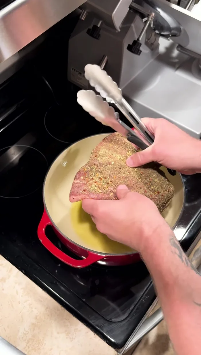 Sear the bottom round roast on all sides in a hot pan.