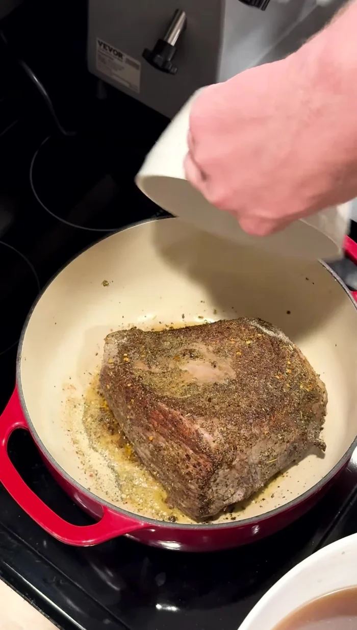 Place the seared roast in the roasting pan. Pour the beef base mixture over the roast. Add celery, quartered onion, bay leaves, and carrots.