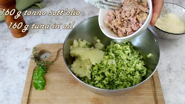 In a bowl, combine the mashed potatoes, drained tuna, parmesan, salt, pepper, basil, thyme, and 50g of breadcrumbs. Mix well. Add more breadcrumbs if needed to achieve a good consistency.