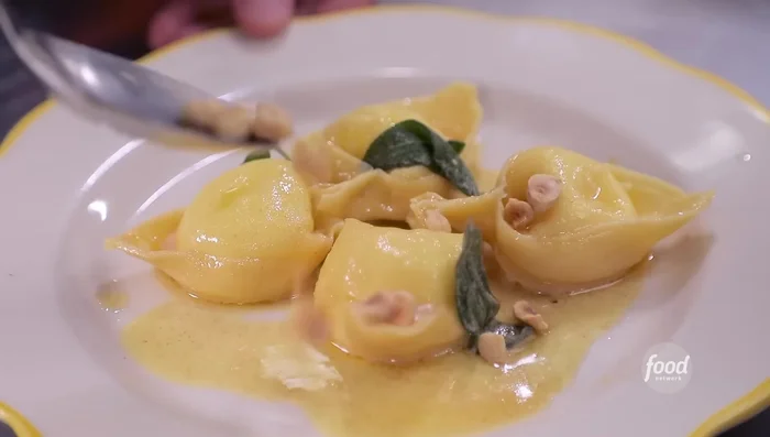 Toss the cooked tortelli in the brown butter sage sauce. Drizzle with balsamic glaze.