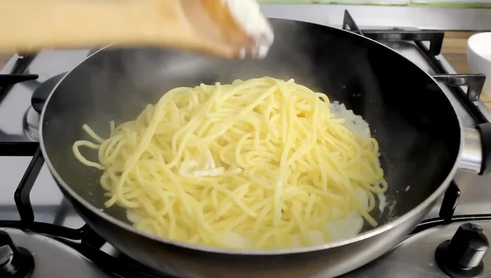 Add the drained tagliolini back to the pan with some pasta water and mix well.