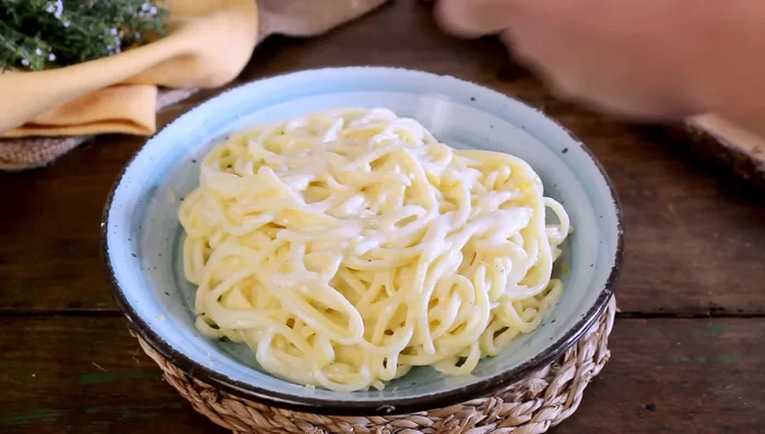 Plate the lemon tagliolini and garnish with grated lemon peel and thyme.