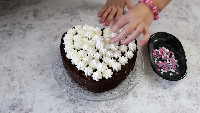 Decorate the cake with pink, purple, and white heart sprinkles.