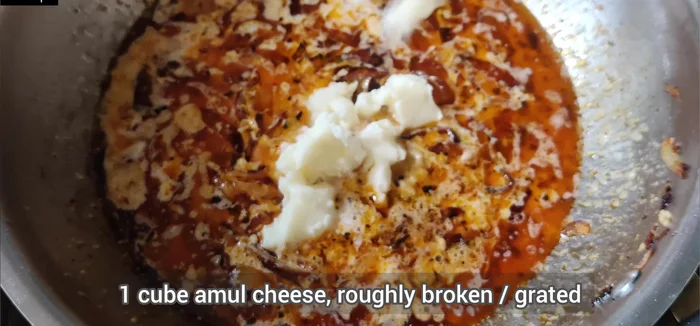 Add 1 cube of roughly broken Amul processed cheese (or grated cheese) and mix well until melted.