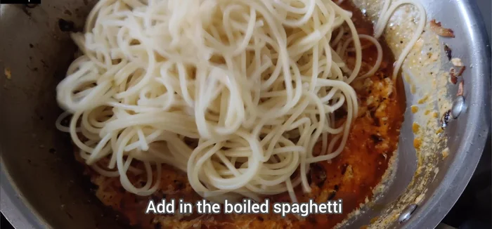 Add the boiled spaghetti to the sauce and mix thoroughly to coat the pasta evenly.