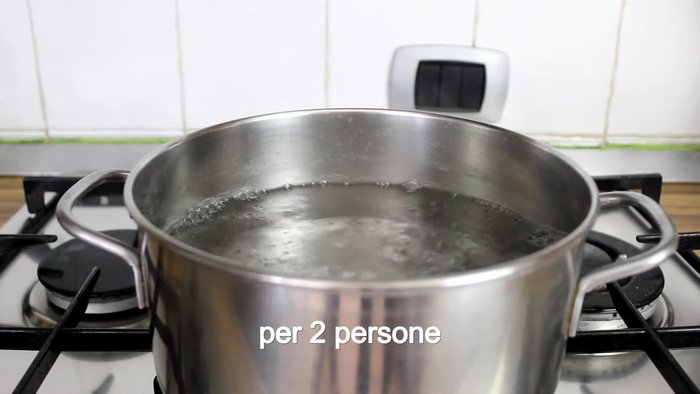 Boil water in a pot, add salt, and cook 200g of paccheri pasta al dente.