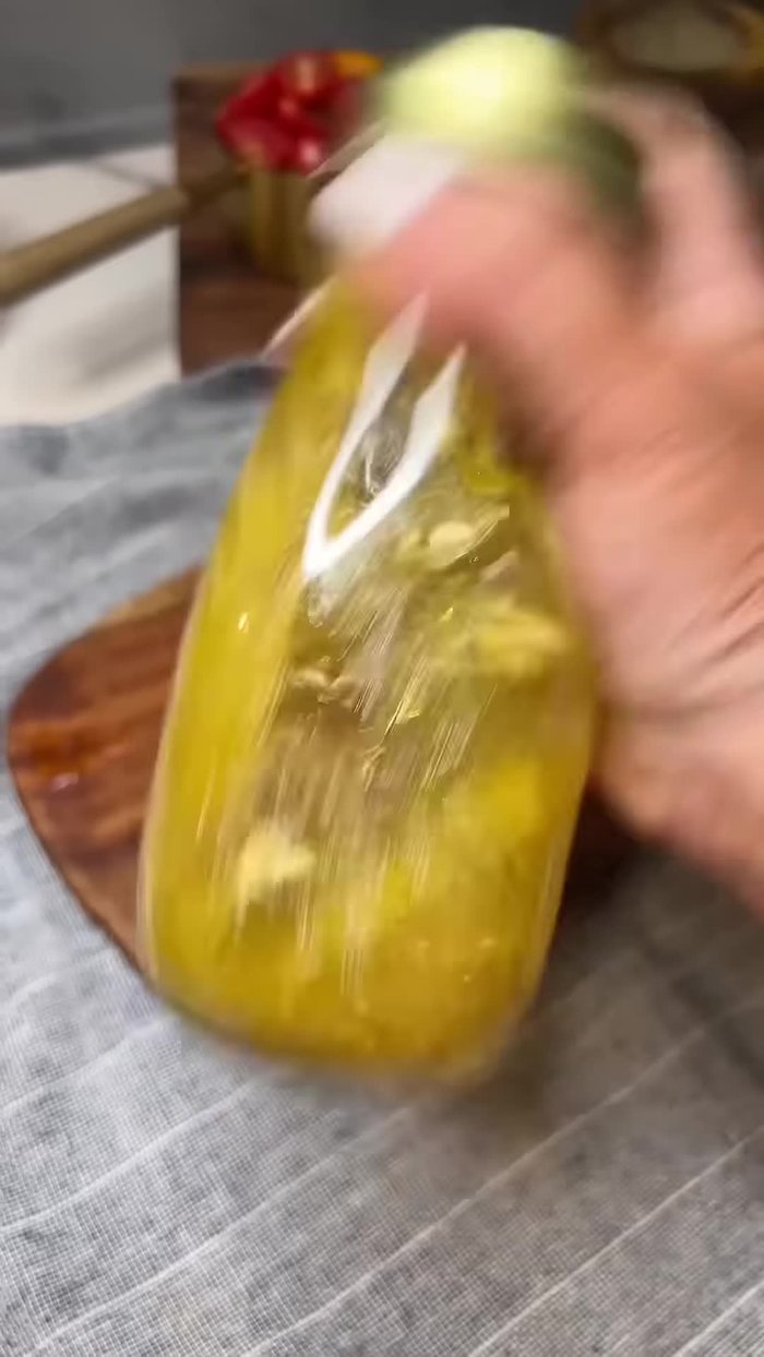 Pour a little dressing in the bottom of a salad bowl. Add the cooked orzo while it's still warm.