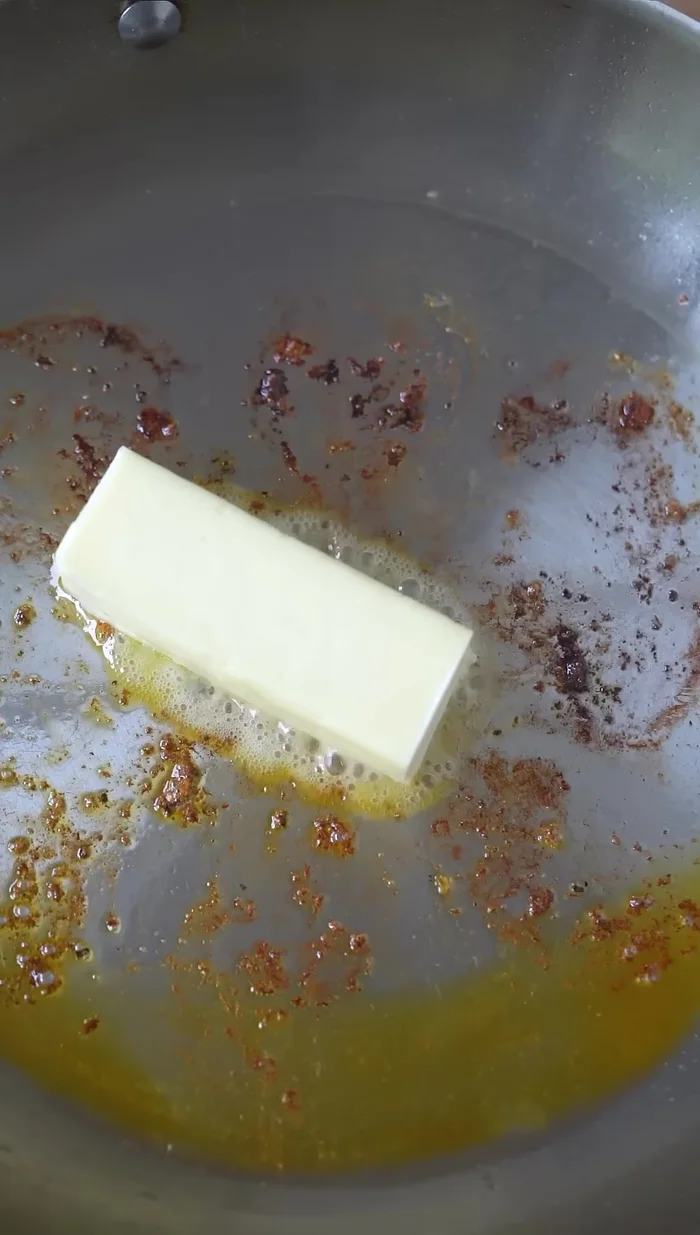 Add butter. Once melted, add diced white onion and cook until translucent.