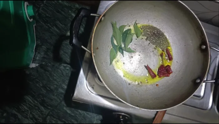 Temper the chutney with mustard oil, mustard seeds, dried red chilies, and curry leaves.