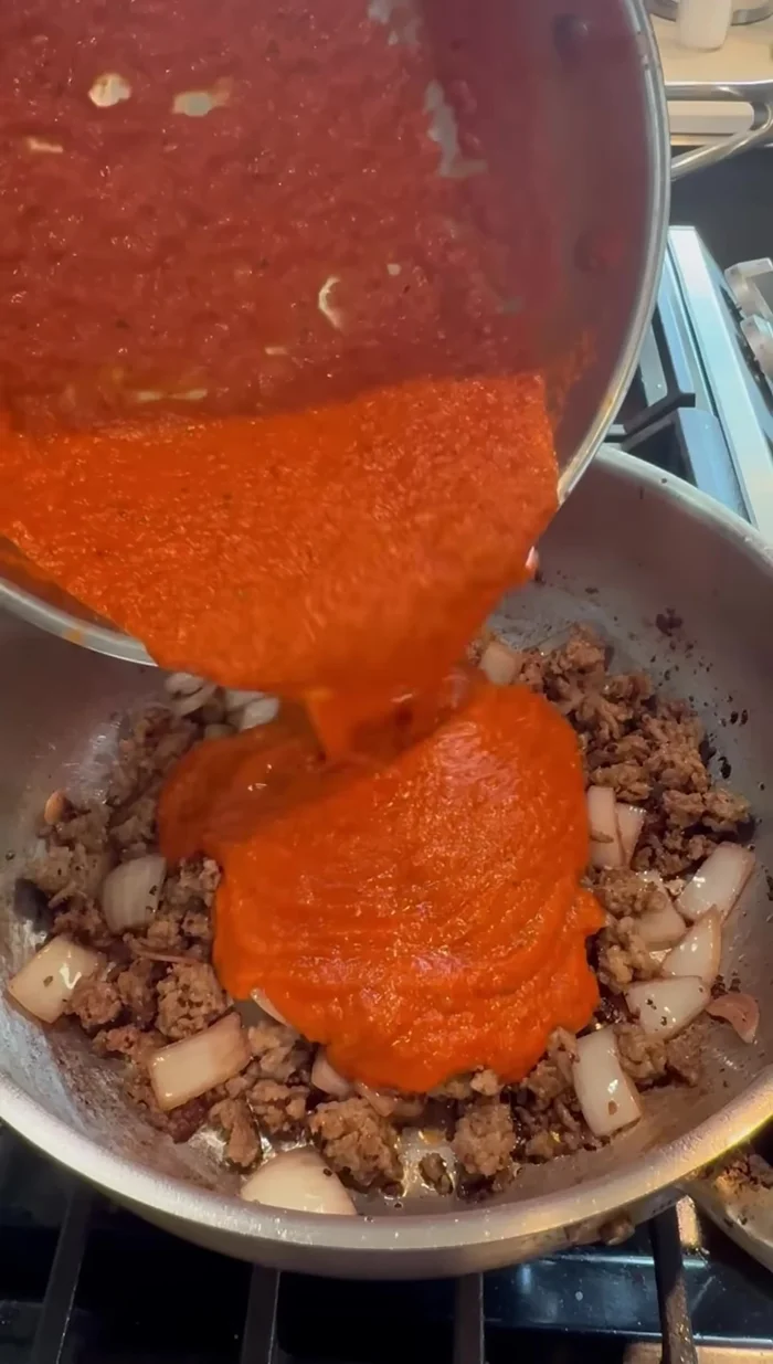 Add the prepared tomato sauce to the pan with the sausage.