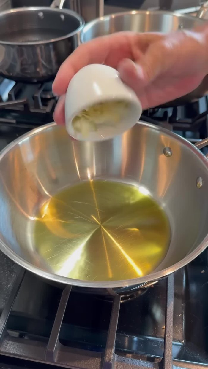 Start by making the sauce. Add enough olive oil to cover the bottom of the pan. Add sliced garlic and let it brown slightly.
