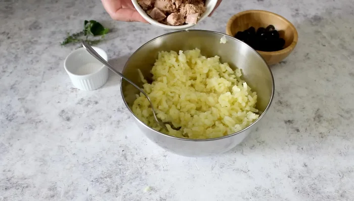 Add 180g drained tuna, 40g sliced olives, salt, chopped basil (or thyme), and a little lemon zest.