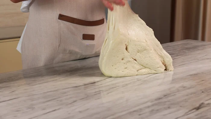Divide and shape: Lightly oil a surface, turn out the dough, and cut it into pieces. Fold each piece into an envelope shape, seam-side down, and place in oiled containers to proof.