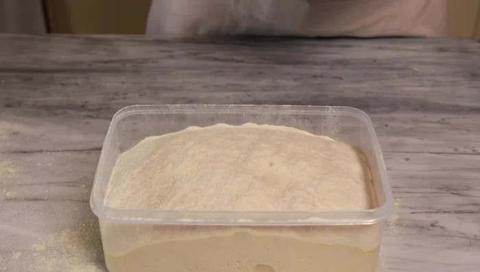 Prepare pizza: Dust your surface with semola rimacinata. Gently stretch and shape the dough on the semolina, aiming for a uniform base with a thicker edge.