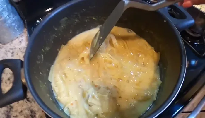Once the shrimp is cooked, add cream of mushroom soup to the pasta.