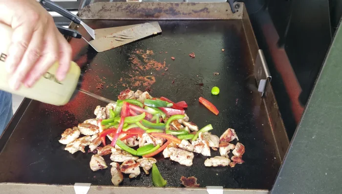 Add bell peppers to the griddle and sauté with the chicken.