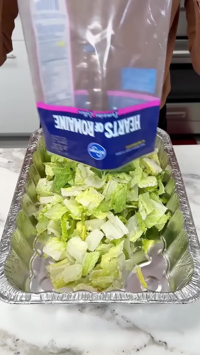 Start with two bags of Hearts of Roma lettuce in a large bowl.