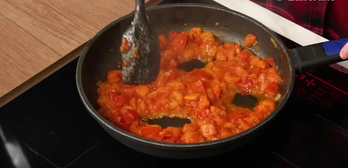 Prepare spaces for the eggs in the tomato sauce using a spatula. No need for perfect holes, just create small spaces.