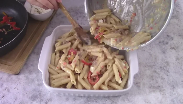 Transfer pasta mixture to a baking dish. Top with remaining peppers, sausage, half of the mozzarella, and parmesan cheese.
