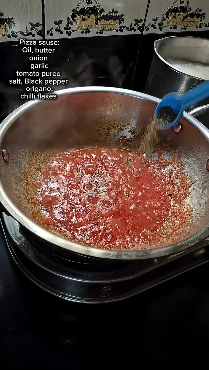 Season the pizza sauce with salt, black pepper, oregano, and chili flakes. Cook until well combined.